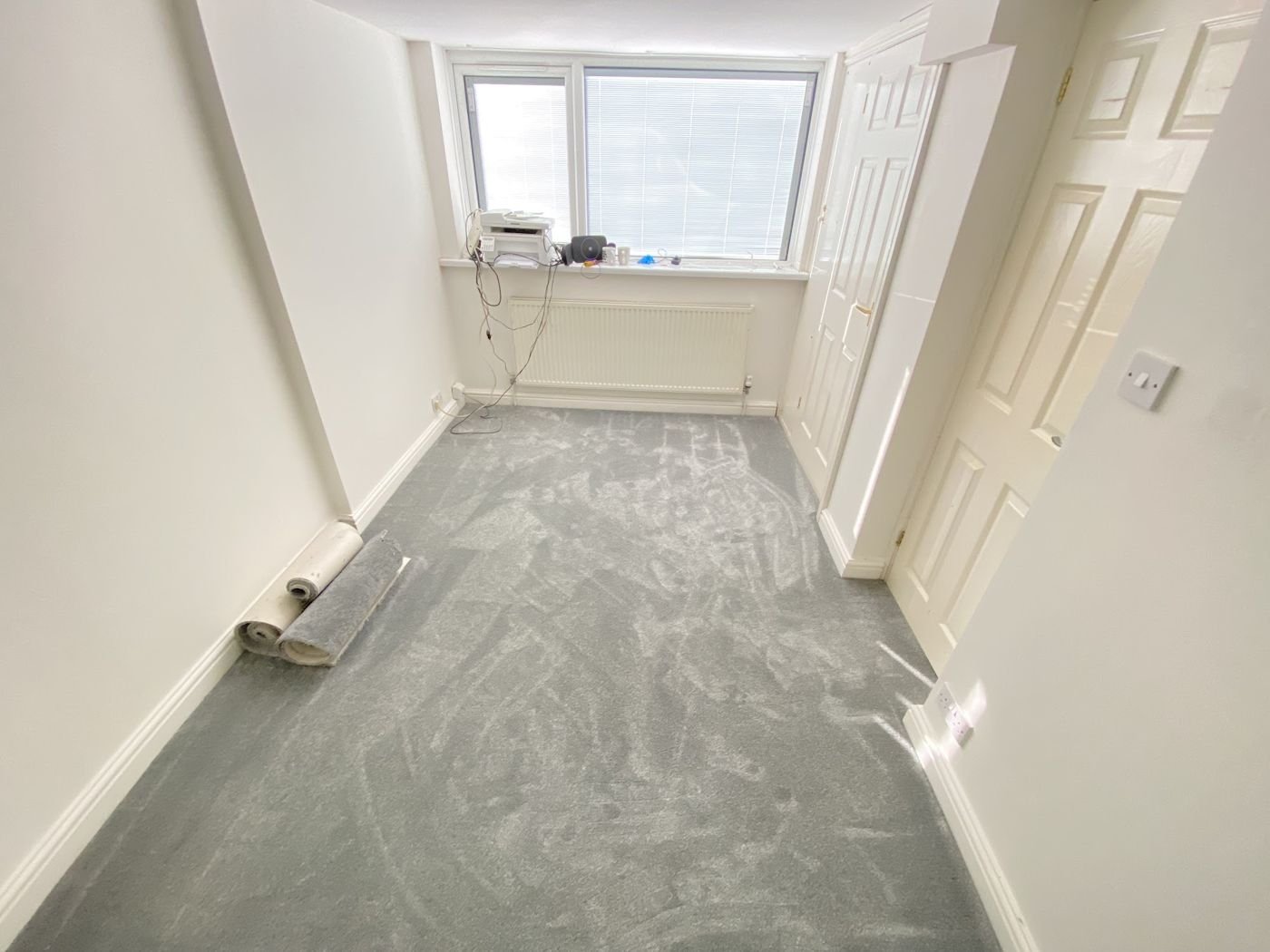 Long room with carpet fitted and a roll left by the wall